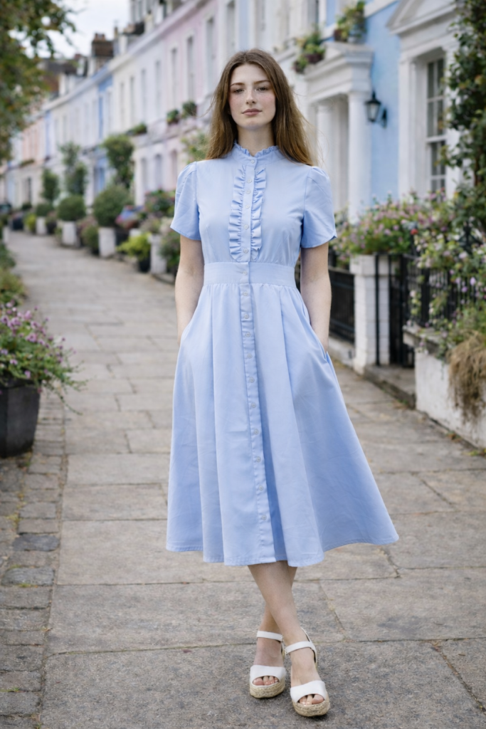 Sky blue midi dress with mother-of-pearl buttons, ruffle front, fitted waist, hidden side-seam pockets, and flowing pleated skirt by BIBI SAKALIEVA