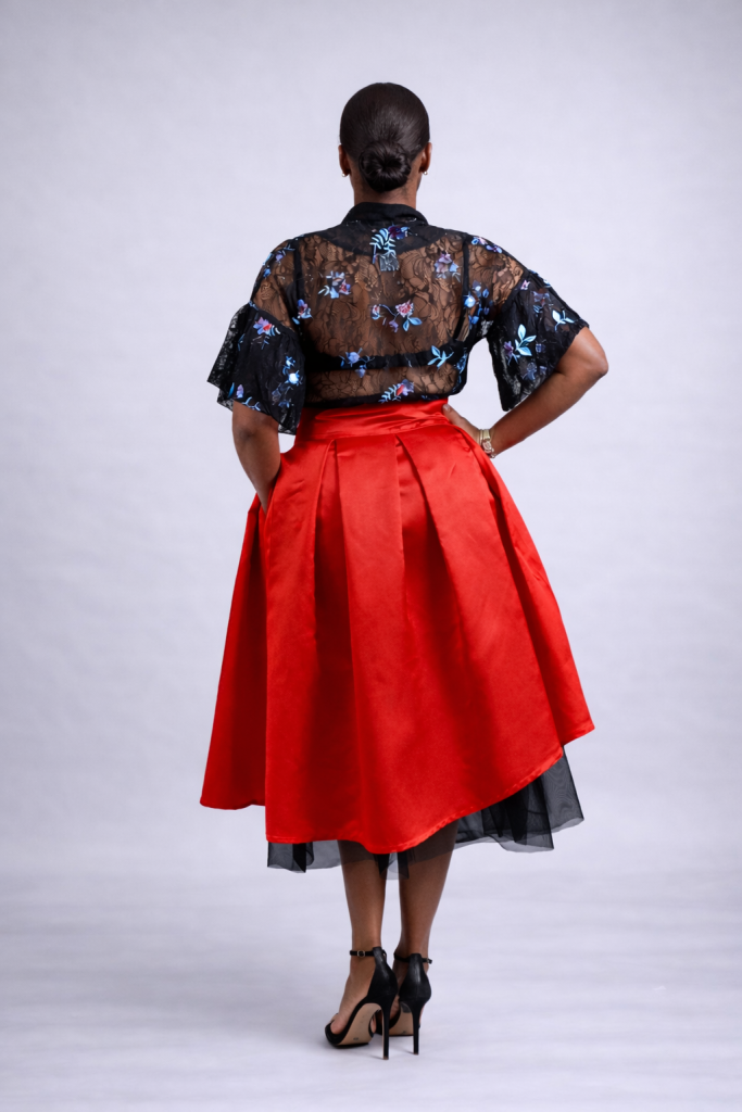 Red pleated midi skirt with asymmetric satin hem and soft black tulle underlayer