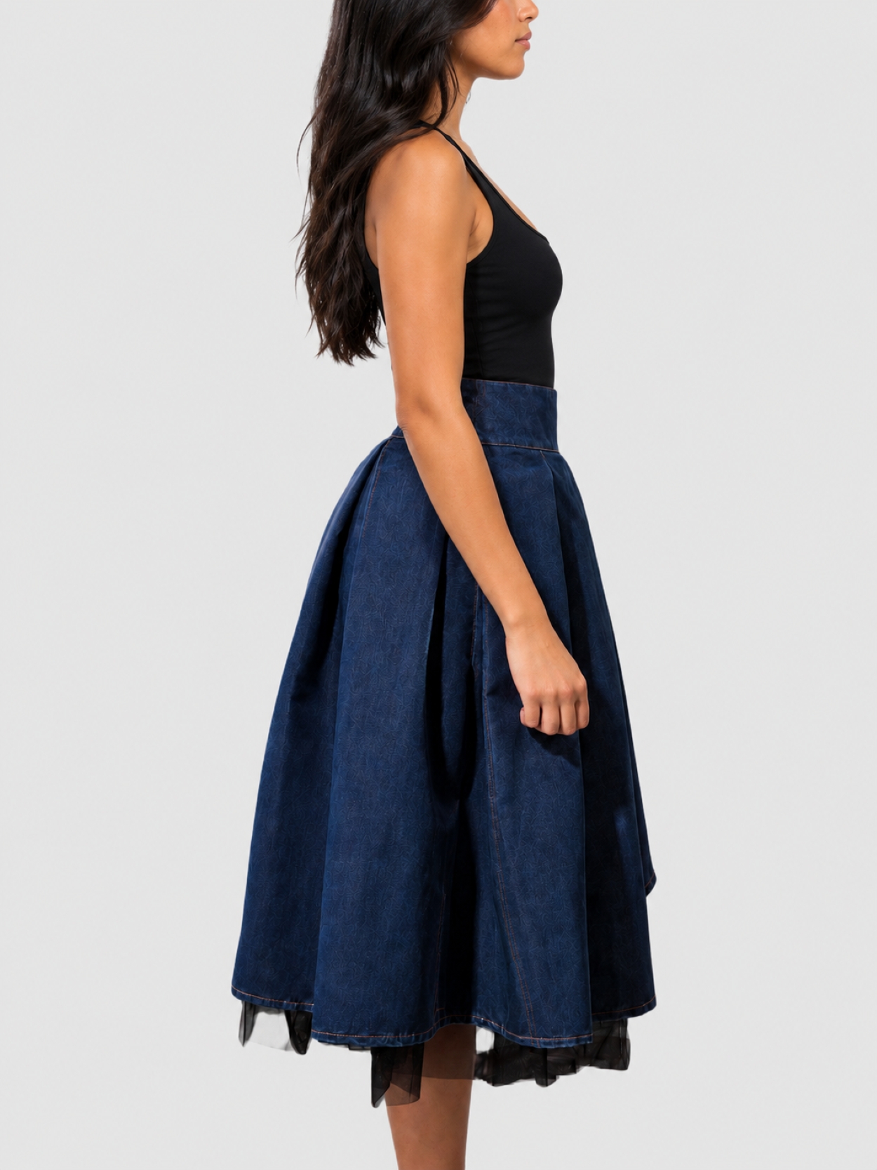 Model wearing BIBI SAKALIEVA asymmetric pleated indigo denim midi skirt with black tulle
