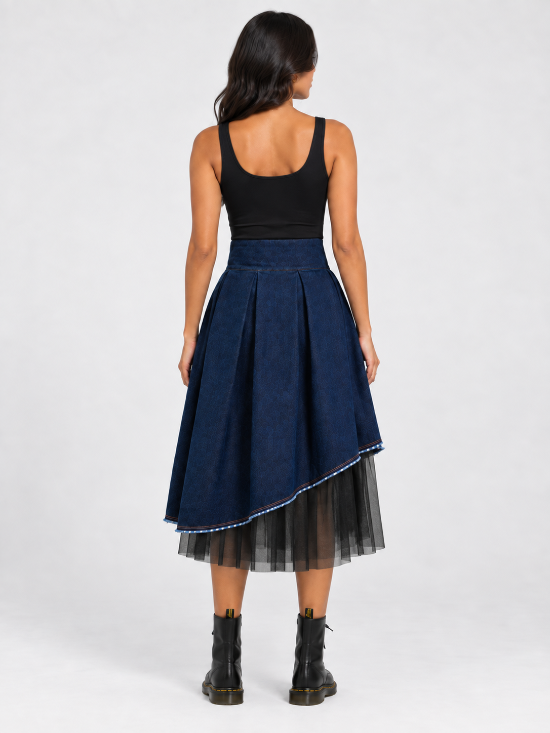 Model wearing BIBI SAKALIEVA asymmetric pleated indigo denim midi skirt with black tulle